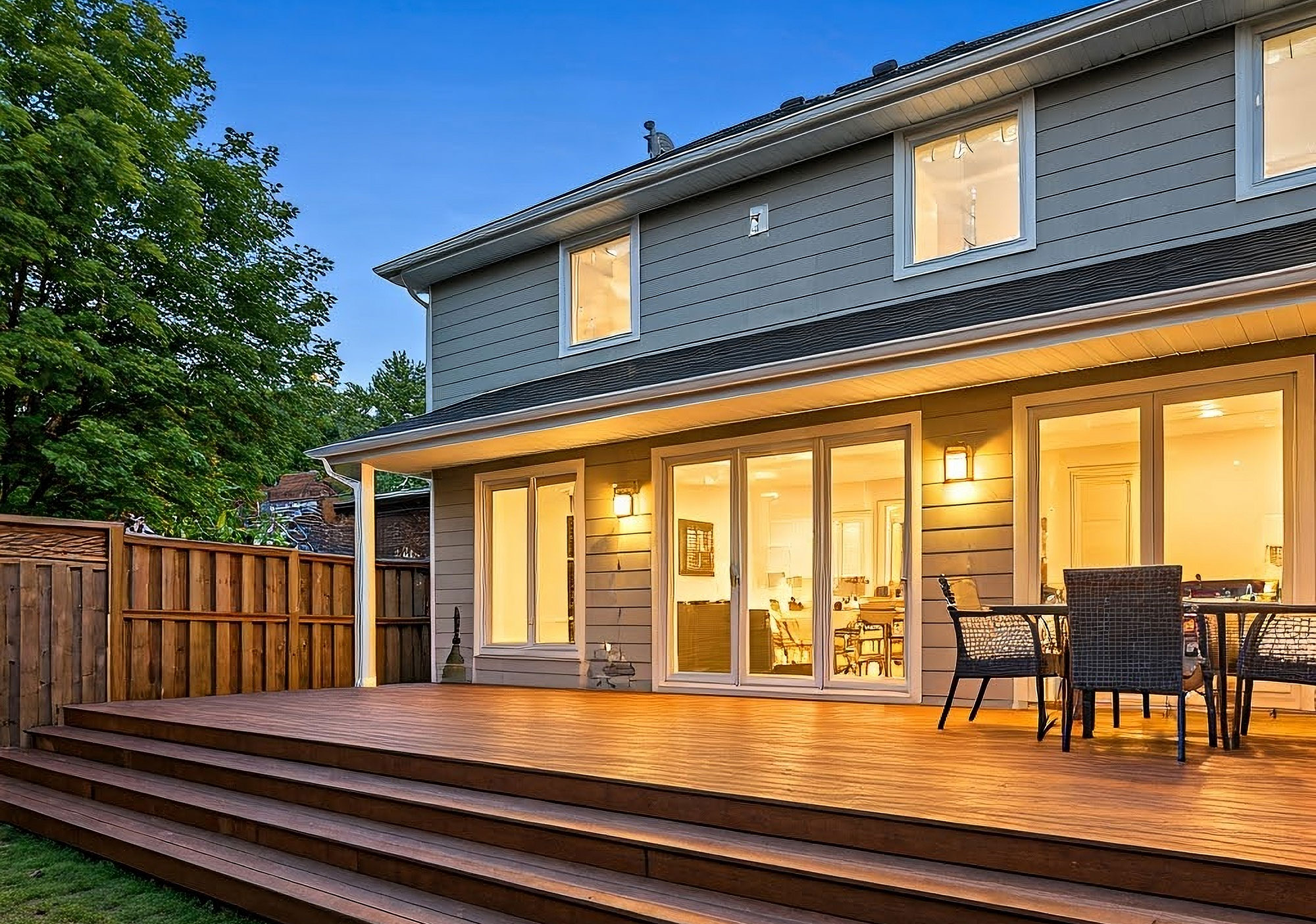 Modern home exterior with deck at dusk